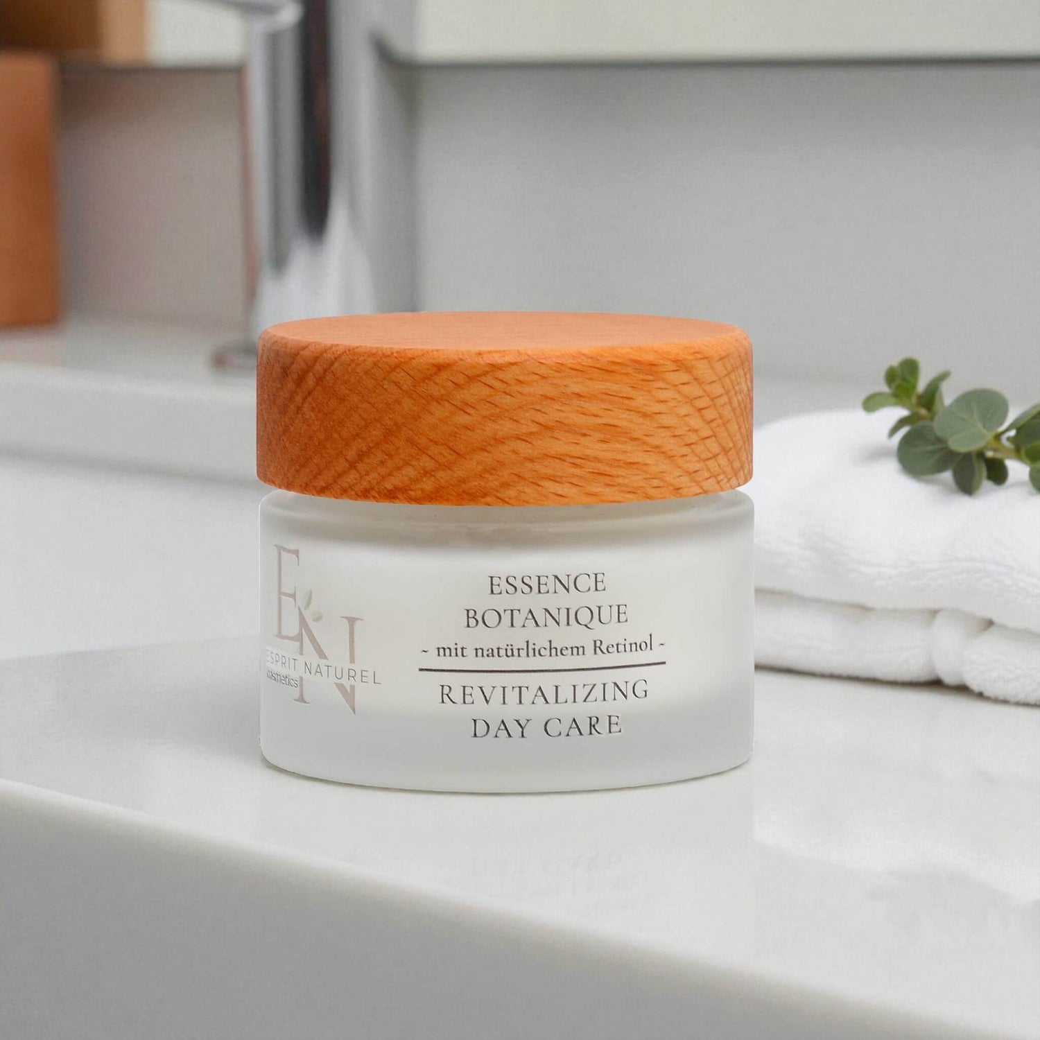 Esprit Naturel – palmölfreie Rejuvenating Day Care in einem edlen Glastiegel mit Holzdeckel, präsentiert auf einer weißen Keramikfläche vor natürlichem Badezimmer-Hintergrund